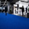 CRIS-048_70 Blauer Messeteppich in einer modernen Halle mit laufenden Menschen.