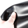 GL1100_40-jpg Hand hält flexible, glatte schwarze SBR-Gummimatte in Nahaufnahme.