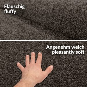 Hand berührt den flauschigen, einfarbigen Kurzflor Teppich Prinsess in Grau